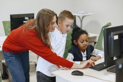 Teacher and students at computer- Stereotypes in Computer Science